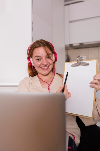 Female teacher showing students in online class the lesson on notepad