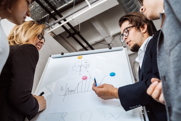 Businesspeople with whiteboard discussing strategy in a meeting – Free Stock Photo