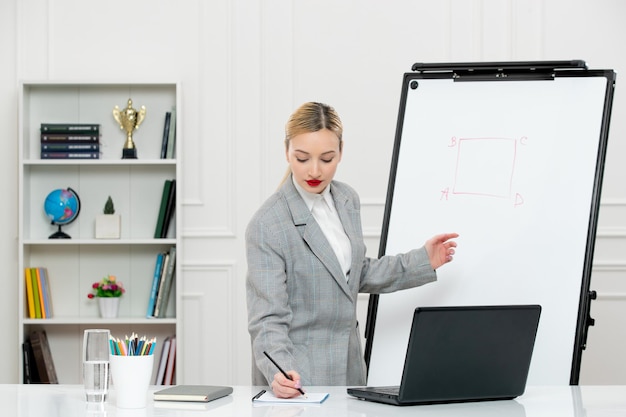 Teacher young cute instructor in suit in classroom with laptop and whiteboard writing notes