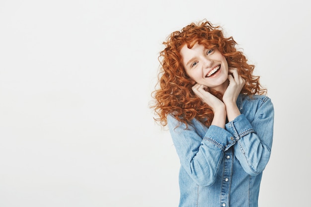 Happy beautiful girl with curly red hair smiling