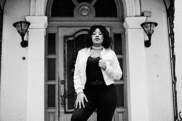 Stylish African American Plus Size Model Walking on City Streets with House Entrance in Background