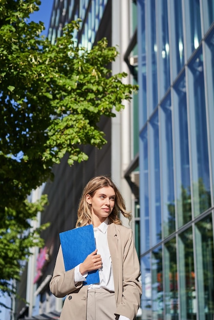 Confident Saleswoman Poses Near Office Building in Beige Suit