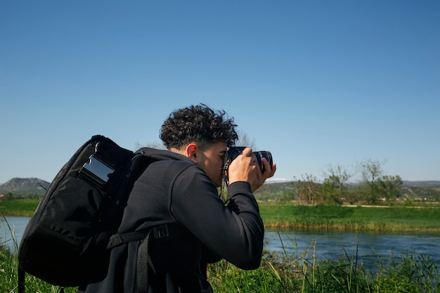 Man with Backpack Capturing Flowing Water – Free Stock Photo for Download