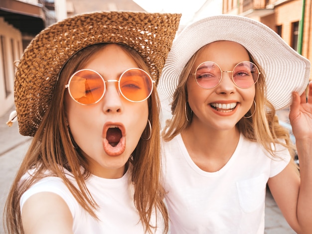 Young Smiling Hipster Blond Women Taking Selfie Photos in White T-shirt