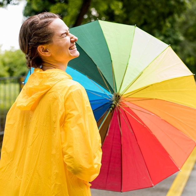 Smiley woman holding a colorful umbrella – Free Stock Photo