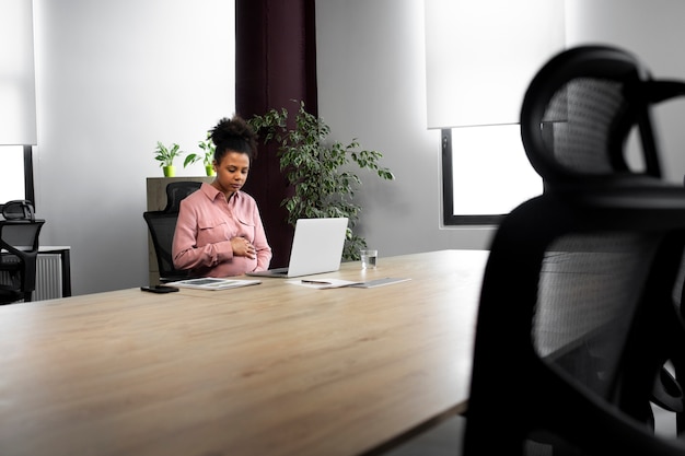 Medium Shot Pregnant Woman Working at Desk