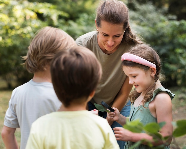 Teacher and Kids Examining Leaves in Nature – Free Stock Photo Download