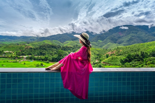 Woman enjoying rice terrace viewpoint and green forest in Nan, Thailand