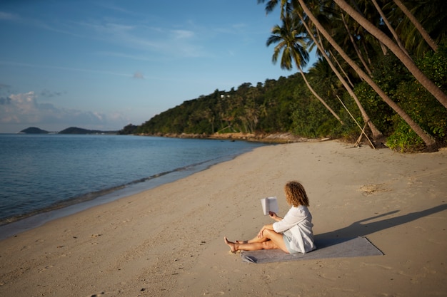 Woman reading on beach – Free to download stock photo