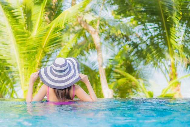 Portrait of a Beautiful Young Asian Woman Smiling and Relaxing Around an Outdoor Swimming Pool in a Resort Hotel on a Holiday Vacation Travel Trip