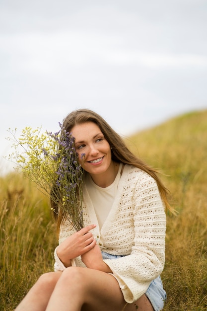 Side view smiley woman holding flowers free stock photo