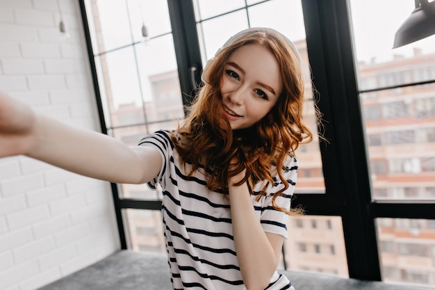 Pretty Girl with Ginger Curly Hair Taking Selfie: Free Download