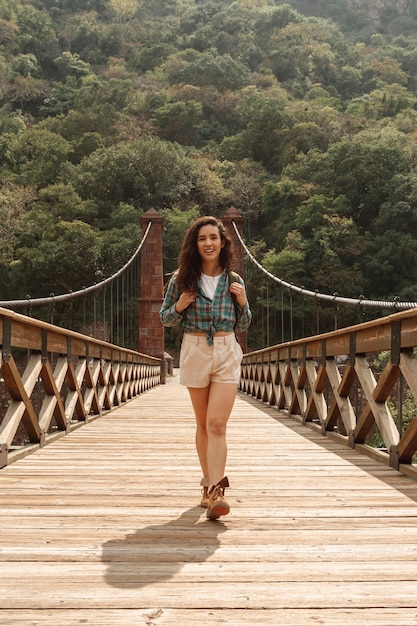 Front view smiley adventurier woman on bridge – Free Stock Photo Download