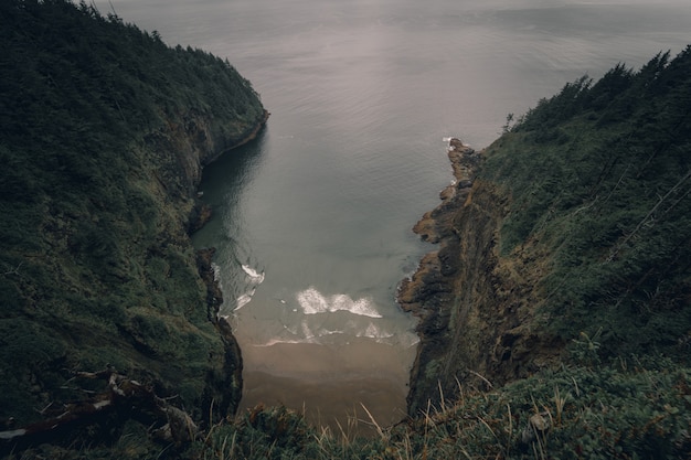 High angle shot of a water canal in between steep green hills