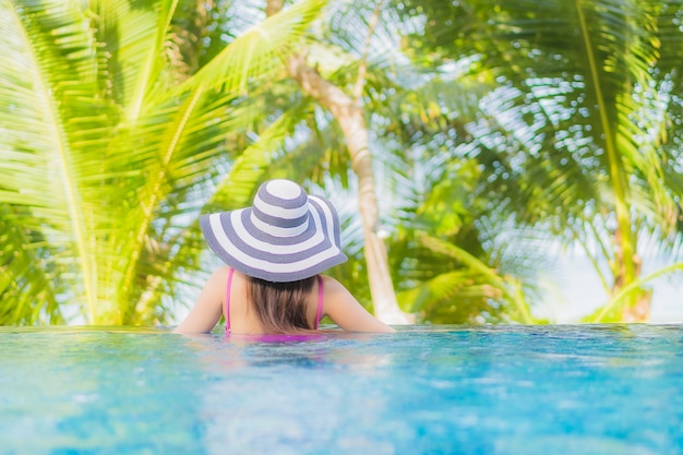 Portrait beautiful young asian woman smile relax around outdoor swimming pool in resort hotel on holiday vacation travel trip