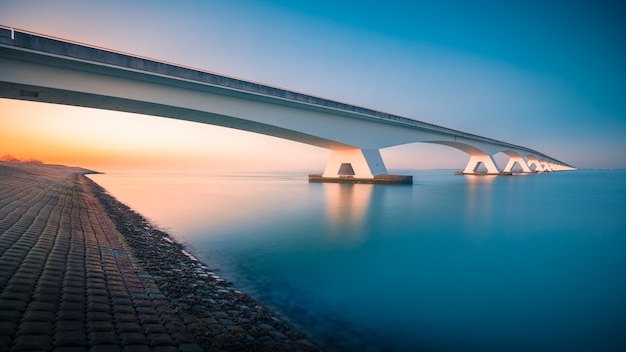 Breathtaking view of a bridge over a peaceful river in Zeelandbridge, Netherlands – Free Stock Photo Download