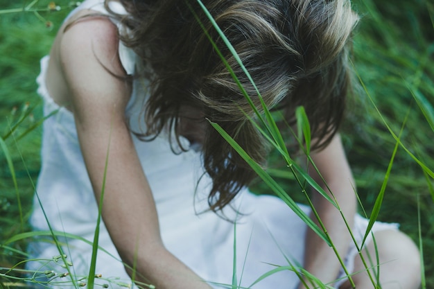 Faceless Woman Sitting in Field