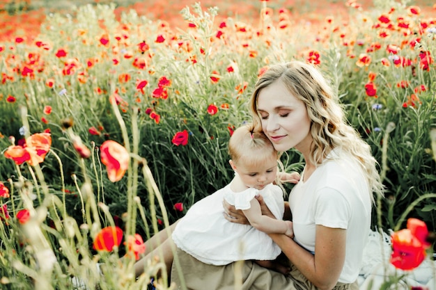 Woman Snuggling with Baby in Poppy Field