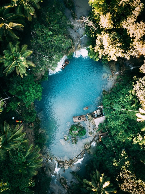 Beautiful Waterfall Streaming into the River Surrounded by Greens