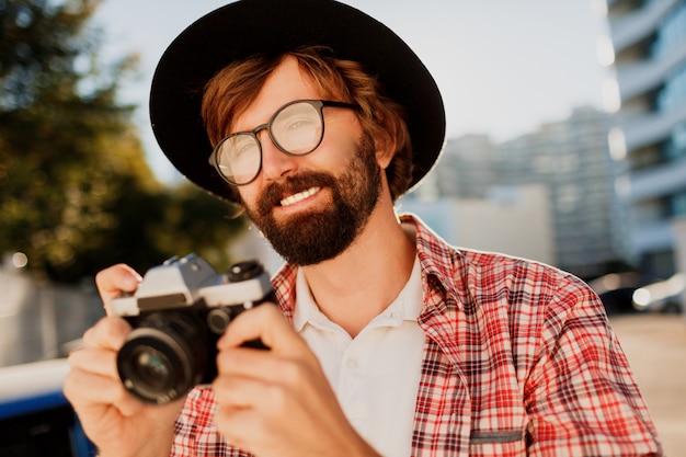 Close up portrait of smiling Hipster beard man using retro film camera