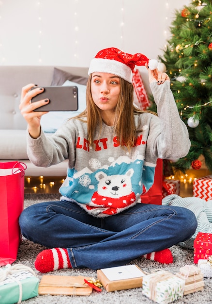 Festive woman pouting lips while taking selfie – Free Stock Photo Download