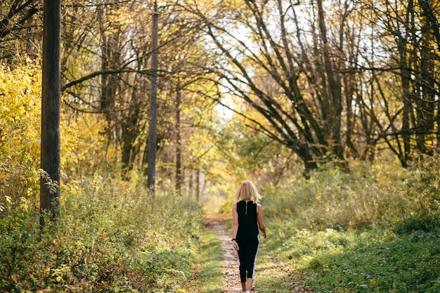 Young girl walking in autumn park