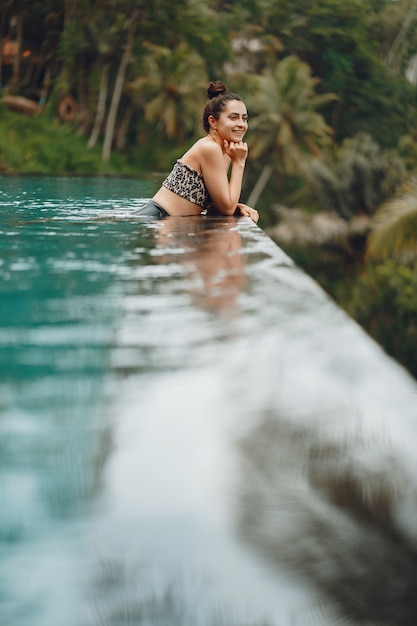 Woman in a swimming pool on a jungle view