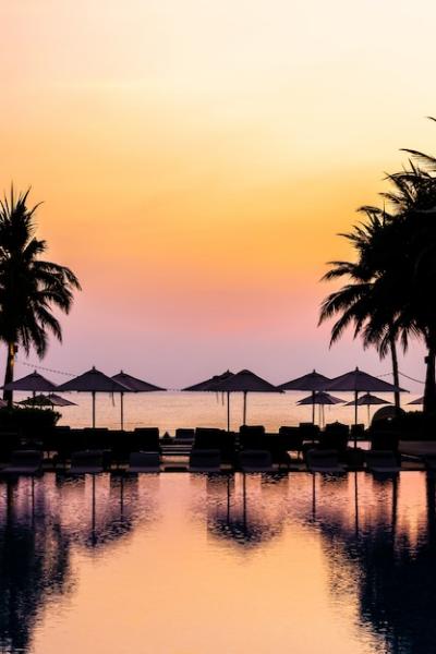 Stunning Sunrise at Outdoor Swimming Pool with Silhouette Umbrella Chairs – Free to Download