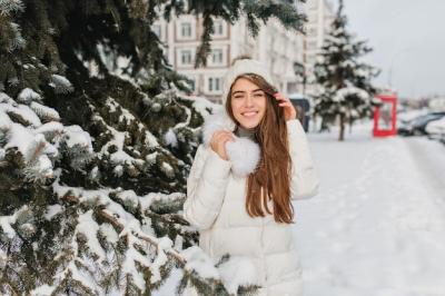 Cheerful Woman in Knitted Hat and Warm Coat Posing Beside Tree – Free Download