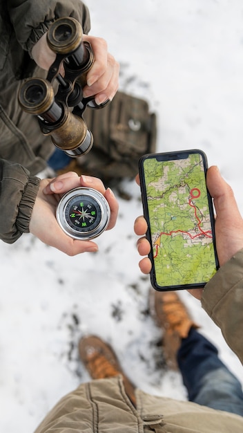 Close-Up of Hands Holding a Phone and Compass – Free Download