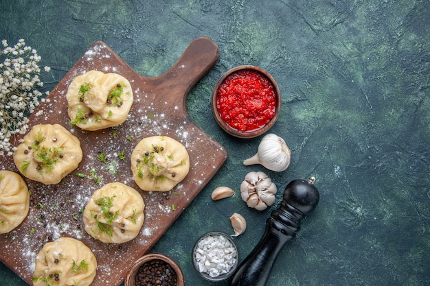 Little Raw Dumplings with Tomato Sauce on Dark Blue Background – Free Stock Photo Download