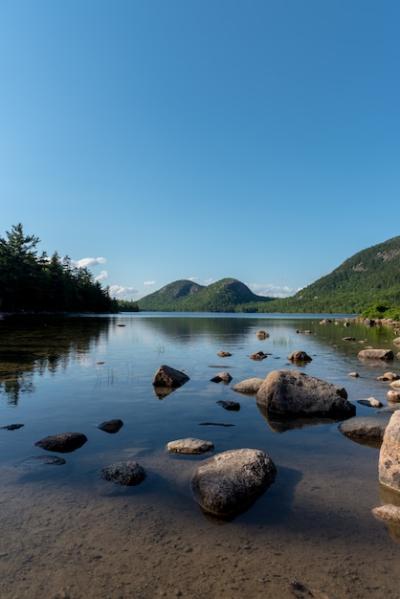 Vertical Shot of a Lake with Big Stones Reflecting the Sky – Free Stock Photo, Download for Free