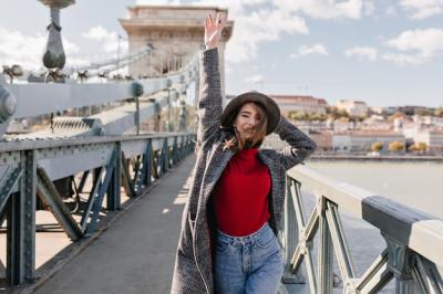 Ecstatic White Female Model Dancing in Tweed Coat on Bridge Over River – Free Download