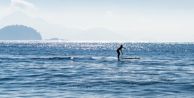 Silhouette of a Woman Paddle Surfing in the Sea, Brazil – Free Download