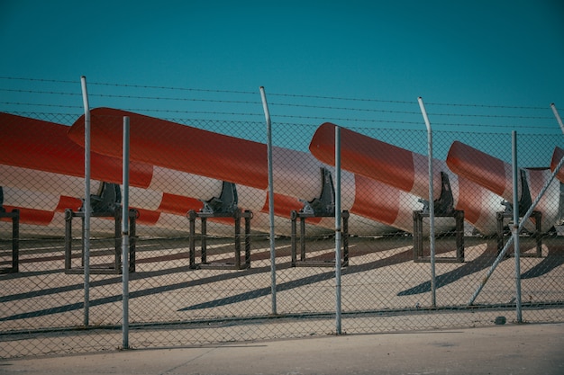 Metal Fence with Barbed Wire and Canoes Against a Blue Sky – Free Download