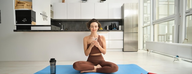 Young Woman Exercising at Home with Mobile Phone – Free Stock Photo for Download