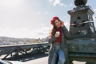 Playful Caucasian Woman Enjoying Coffee in a European Town – Free Download