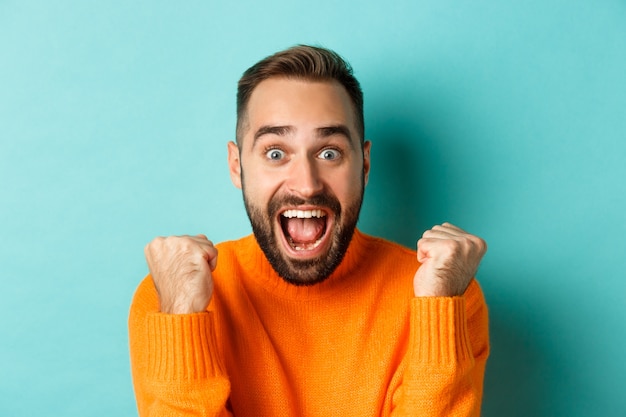 Handsome Relieved Man Celebrating Achievement Against Turquoise Background – Free Stock Photo, Download for Free