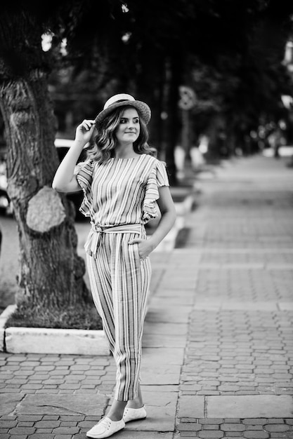 Attractive Young Woman in Striped Overall on Pavement – Black and White Photo – Free Download