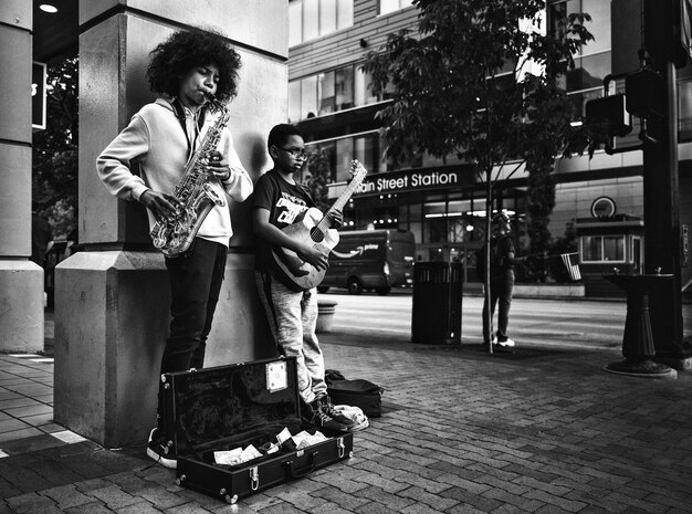 Black Musicians Playing Saxophone and Guitar on City Street – Free Download