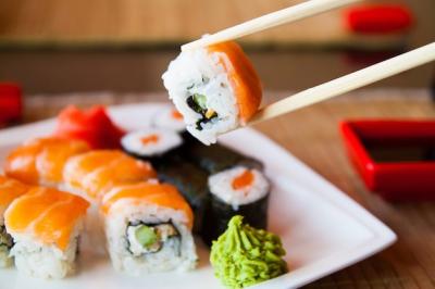 Sushi with Chopsticks Dipped in Sauce – Free Download