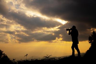 Photographer Capturing a Sunset in the Mountains – Free Download