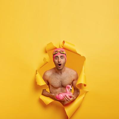 Astonished Young Man with Inflated Pink Flamingo – Free Download