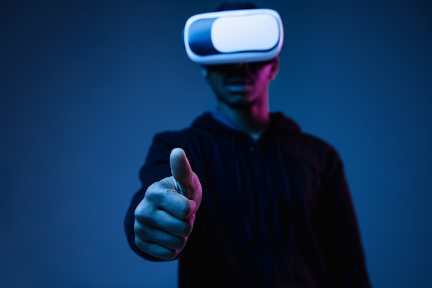 Young African-American Man in VR Glasses Amid Neon Blue Lights – Free Download