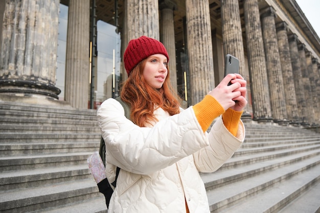 Young Redhead Blogger Capturing Sightseeing Moments on Smartphone – Free Download