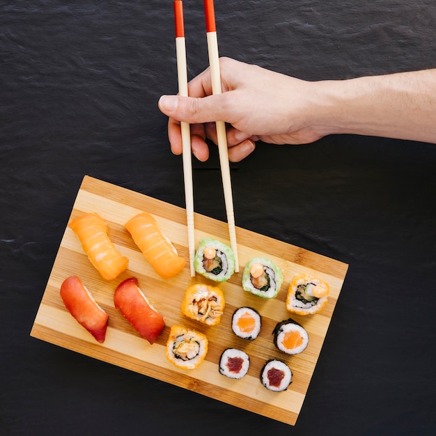 Hand Picking Roll from Wooden Board – Free Stock Photo for Download