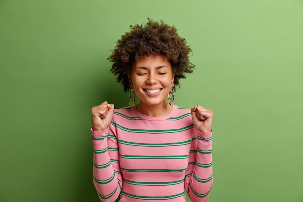 Happy Young Woman Celebrating Success in Striped Sweater – Free Stock Photo, Download for Free