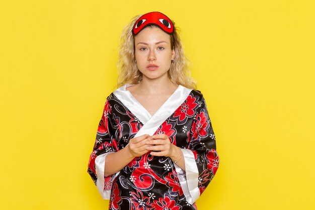 Young Female in Night Robe with Eye Mask Preparing for Sleep Against Light Yellow Wall – Free Stock Photo Download for Free