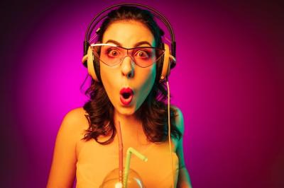 Happy Young Woman in Red Sunglasses Enjoying Music with Trendy Pink Neon Background – Free Download