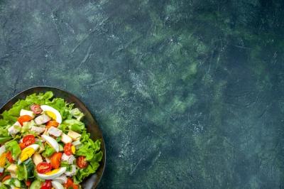 Homemade Delicious Salad on a Black Plate with Green and Black Background – Free Download